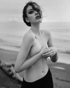 Deva Cassel topless but covered on a beach