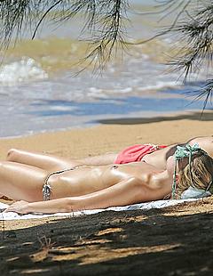 Margot Robbie tanning topless on a beach