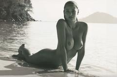 Genevieve Morton lying fully nude on a beach